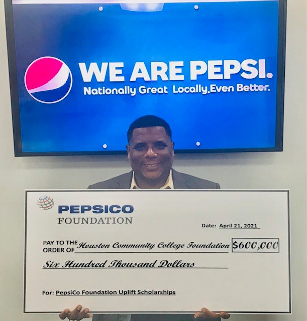 An HCC Foundation member holds a check from PepsiCo