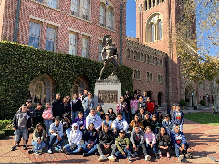 photo of many student sitting around a statue