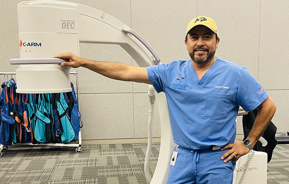 Carlos Castro stands in front of his C-Arm X-ray machine.