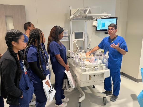 Students and Instructor observing a medical baby manikin in the HCC Simulation Lab