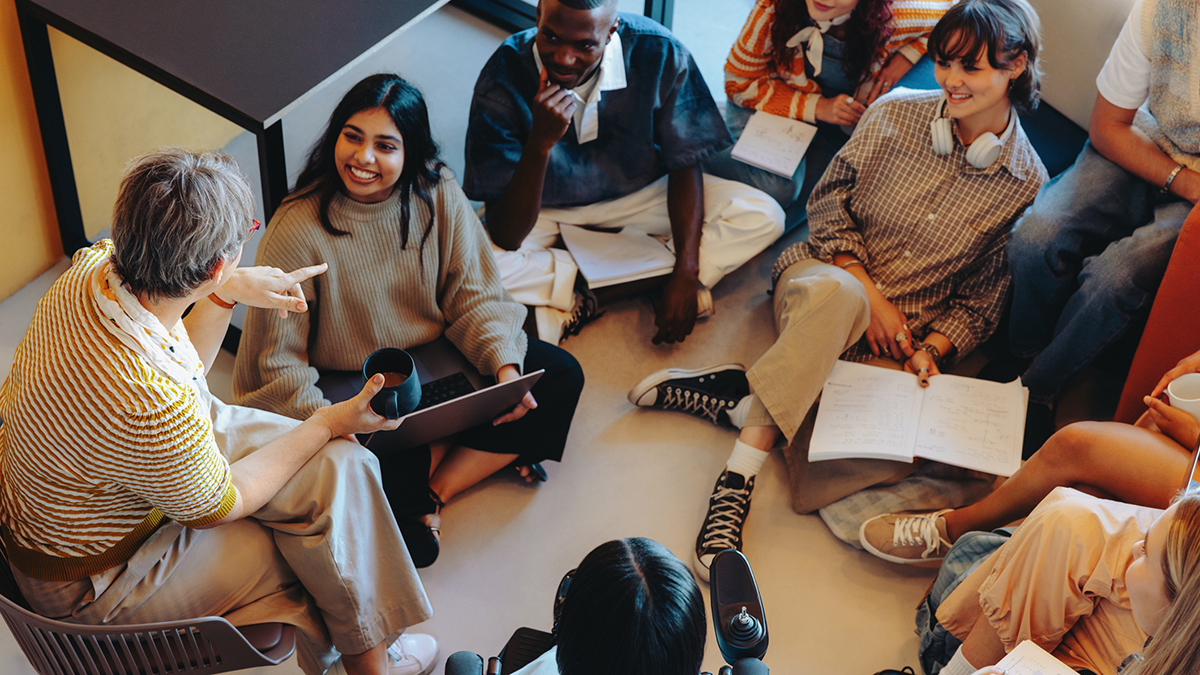 College students sitting around a professor casually during an activity